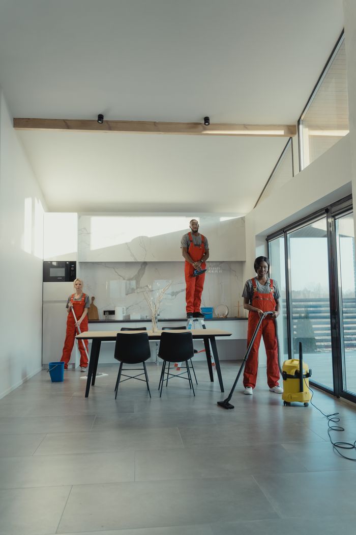 hero-img-02 Team of professional cleaners working in a spacious, modern indoor setting.